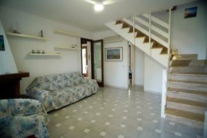 sala de estar con sofá y escalera en Villa Piri, en Sabaudia