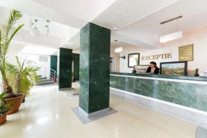 a hotel lobby with a reception counter and plants at Hotel Atlantis in Tulcea