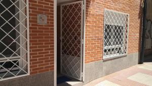 un muro di mattoni con porta e finestra di Apartamento La Galatea ad Alcalá de Henares