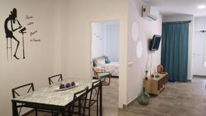 a living room with a table and chairs and a bedroom at Apartamento La Galatea in Alcalá de Henares