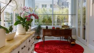 a living room with a desk and a red rug at Villa Guidi 10 Emma Villas in Milano Marittima