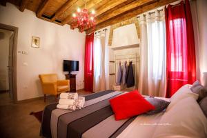 een slaapkamer met een groot bed met rode gordijnen bij Sole e Vento in Chioggia