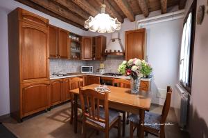 een keuken met houten kasten en een tafel met bloemen erop bij Sole e Vento in Chioggia