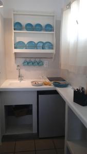 - un comptoir de cuisine avec évier et plats bleus dans l'établissement ViewLight Sifnos Living, à Apollonia