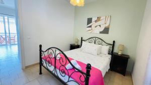 a bedroom with a black and white bed with a pink blanket at Panoramic sea view1bedroom Apart.Glyfada beach2-4p in Glyfada