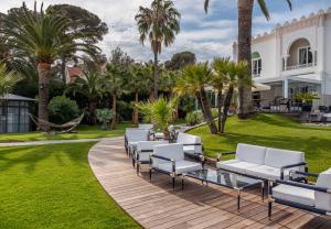 a row of white lounge chairs on a wooden deck at La Villa Mauresque in Saint-Raphaël
