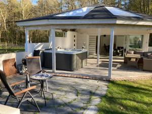 a gazebo with a hot tub in a backyard at Davidslids cottage in Löddeköpinge