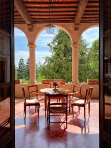 a patio with a table and chairs on a porch at Villa Sardi Small Luxury boutique Hotel in Lucca