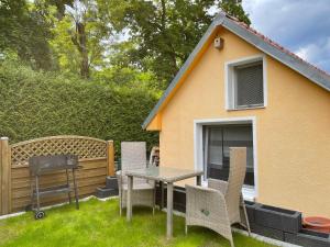 een achtertuin met een tafel en stoelen en een huis bij Tiny House in Burig