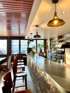 ein Restaurant mit einer Bar mit Stühlen und Tischen in der Unterkunft Auberge du Cheval Blanc Logis in Chamouilley