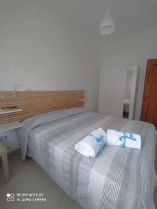 - une chambre avec un grand lit et des serviettes dans l'établissement APPARTAMENTO SANTUCCI, à Rodi Garganico
