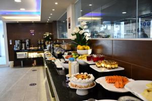 a buffet line with different types of food on plates at Delfines Collection Hotel by Mercure in Santa Cruz de la Sierra
