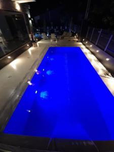 una piscina azul por la noche en LUXSUITES, en Ofrinion