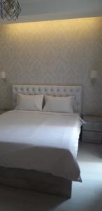 een slaapkamer met een wit bed met witte lakens en kussens bij sharing apartment kutaisi in Koetaisi