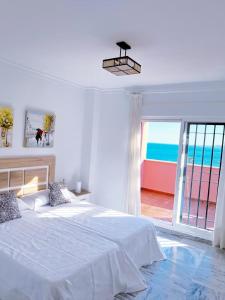a bedroom with a bed and a view of the ocean at SUNNY HOUSE AT THE BEACH infinity pool shared in Benalmádena