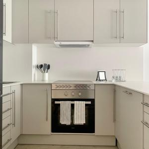 a kitchen with white cabinets and an oven at New Apartment La Massana - Telecabina to Bike Park in La Massana