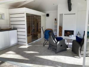 a living room with two chairs and a fireplace at Davidslids cottage in Löddeköpinge