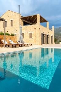 a villa with a swimming pool in front of a building at Kika Residences in Agios Nikolaos