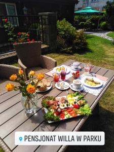 ポラニツァ・ズドルイにあるPensjonat Willa w Parkuの花と食べ物を盛り付けたピクニックテーブル