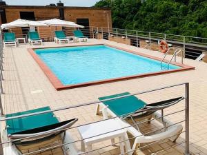 uma grande piscina com cadeiras em Hotel Giò Wine e Jazz Area em Perugia