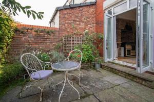 two chairs and a table in front of a building at Victorian Villa close to Liverpool City Centre in Liverpool