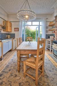 una cucina con tavolo in legno, sedie e lampadario pendente di Victorian Villa close to Liverpool City Centre a Liverpool