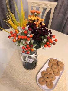 een vaas met een boeket fruit en koekjes op een tafel bij sharing apartment kutaisi in Koetaisi