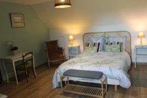 a bedroom with a bed and a chair and a table at ROC callac in Saint-Gilles-du-Vieux-Marché