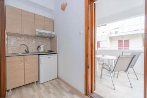 una cucina con lavandino e tavolo con sedia di Sofias Studios East Home a Néos Marmarás