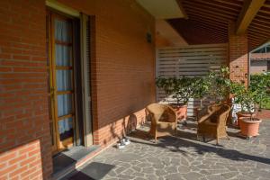 zwei Stühle auf einer Terrasse neben einem Gebäude in der Unterkunft Casa vacanze Gemma Toscana in Capannoli