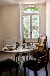 mesa y sillas en una habitación con ventana en Villa des Antiquaires, en Bédarieux