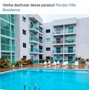un hôtel avec une piscine devant un bâtiment dans l'établissement APARTAMENTO EM PEROBA - MARAGOGI, à Maragogi