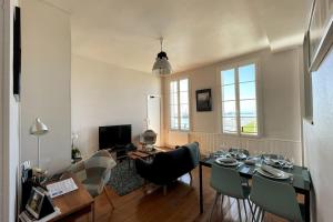 - un salon avec une table à manger et des chaises dans l'établissement "L'amarrage" 2 chambres Perret Pleine Vue Mer, au Havre