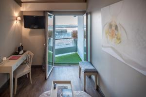 Cette chambre comprend un bureau et offre une vue sur un balcon. dans l'établissement Hôtel de La Marée - Face à l'océan - Ile de Ré, à Rivedoux-Plage