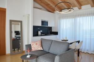 uma sala de estar com um sofá cinzento e uma mesa em Golf Jesolo Village ➔ Attico con Piscina em Lido di Jesolo