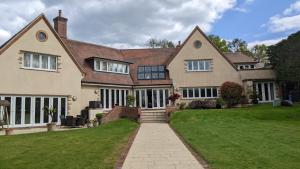 a large house with a lawn in front of it at Greater London Villa in Chelsfield
