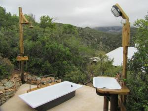 a bathroom with a bath tub and a sink at Joel's Off Grid Cottage in the Klein Karoo in Oudtshoorn