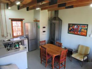 een keuken met een houten tafel en een koelkast bij Joel's Off Grid Cottage in the Klein Karoo in Oudtshoorn