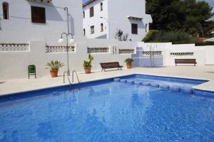 ein Swimmingpool vor einem weißen Gebäude in der Unterkunft AT250 Con piscina, parking, wifi, playa a 150m in Torredembarra