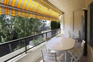 ein Balkon mit Tisch und Stühlen und einem Fenster in der Unterkunft AT250 Con piscina, parking, wifi, playa a 150m in Torredembarra