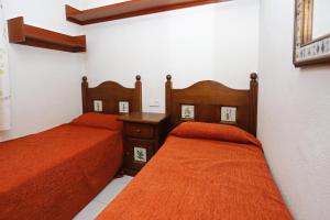 2 Betten in einem Zimmer mit orangefarbener Bettwäsche in der Unterkunft AT250 Con piscina, parking, wifi, playa a 150m in Torredembarra