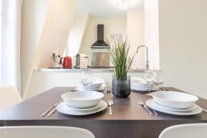 a table with white plates and silverware on it at Sweet Family Vacations - Fairytale Factory in Chessy