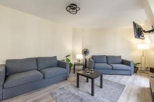 a living room with two blue couches and a table at Sweet Family Vacations - Fairytale Factory in Chessy +17 photos