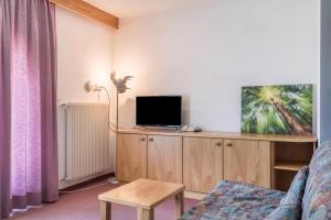 Una sala de estar con un televisor sobre un mueble de madera. en Ferienparadies Sabina Euringer, en Alpe di Siusi
