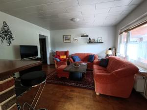 sala de estar con sofá y 2 sillas en Old German Farm House, Appartement, en Aurich