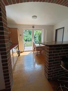 een keuken en eetkamer met een tafel en een bakstenen muur bij Old German Farm House, Appartement in Aurich