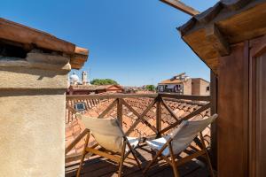 un paio di sedie sedute su un balcone di Casa Violante a Venezia