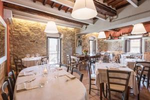 a restaurant with white tables and chairs and brick walls at Locanda La Luna in Tirli