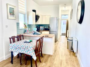 a kitchen with a table with chairs and a refrigerator at Executive apartments, nr city centre with private parking in Plymouth