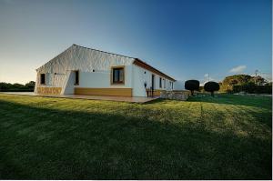 奥德赛克斯Monte Joao Roupeiro - Turismo Rural的草地上的白色小房子